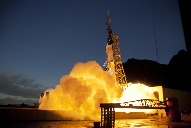 Dramatic close-up photo of a sounding rocket launch with flames, exhaust and bright light.